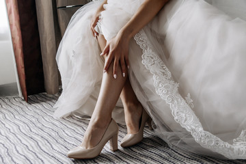 Beautiful legs of the bride in a wedding dress
