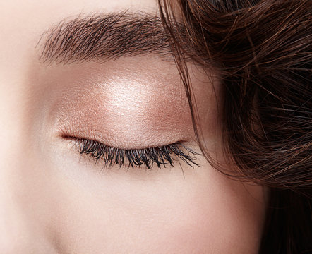 Closeup macro shot of closed female eye. Woman eye with nude makeup and long lashes