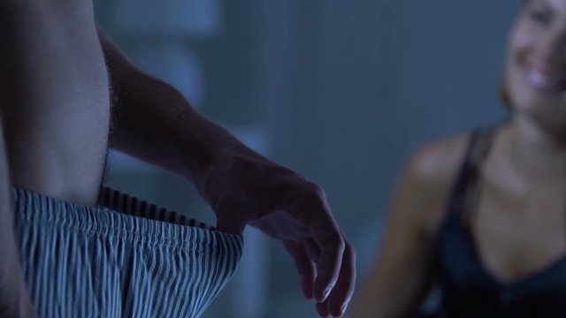 Man looking below waist, woman waiting husband in bed, potency and healthcare
