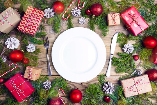 Festive table setting with cutlery and Christmas decorations on wooden table. Top view.