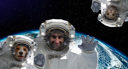 Spaceman with a dog and a cat on the background of the globe. Elements of this image furnished by...