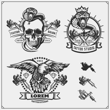 Set of tattoo salon labels, badges and design elements. Tattoo studio emblems with professional equipment, skull, eagle and cobra.