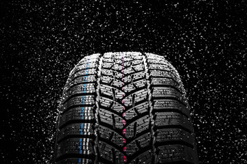 Winter Car tires with snow on black background - obrazy, fototapety, plakaty