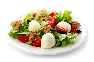 Delicious fresh salad with walnuts on plate, isolated on white