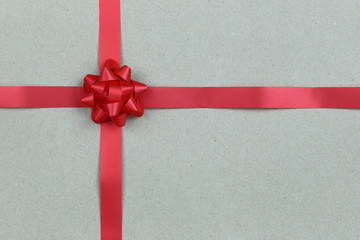 Christmas Red Bow and ribbon on brown paper background.