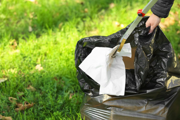 Woman gathering trash in park © Pixel-Shot