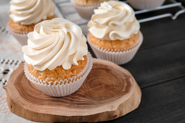 Delicious cupcakes on wooden board