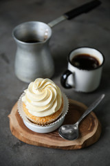 Delicious cupcake with coffee on grey table
