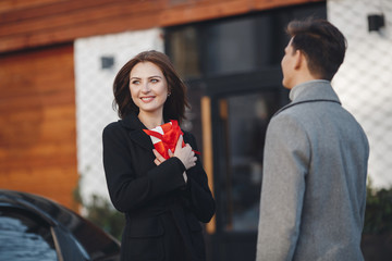 Holidays and events. A gift for the woman he loved.Family couple of man and sexy girl, trust. Slender man and woman with long blond hair, love. Relations of happy family. Loving couple in the city.