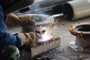 The technician is welding and assembling the steel pipe and flange