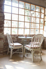 Round table and chairs in cafe vintage style and hanmade brick wall.