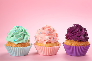 Tasty cupcakes on color background