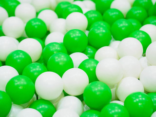 Close up of cGreen and white plastic balls in on children playground.