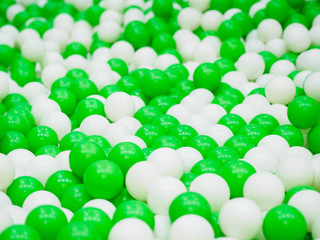 Close up of cGreen and white plastic balls in on children playground.