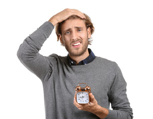 Stressed man with alarm clock on white background