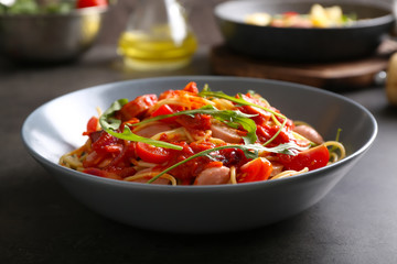 Delicious pasta with sauce and sausages on plate