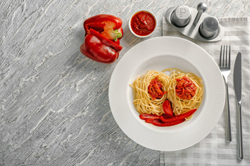 Plate with pasta, sauce and vegetables on table