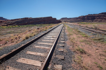 Lost train tracks leading in canyon