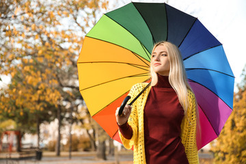 Beautiful fashionable woman with umbrella in autumn park