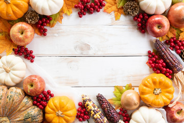 Top view of  Autumn maple leaves with Pumpkin and red berries on white wooden background....