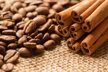Coffee beans, anise and cinnamon on brown burlap. Close up