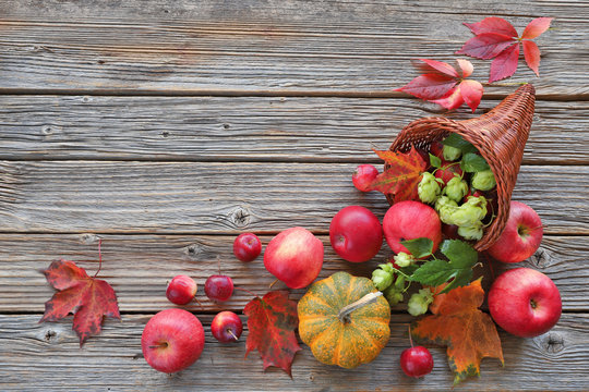 Cornucopia With Apples, Autumn Leaves, Pumpkins,hops  On Wooden Background 