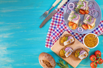 Sandwich with pieces of marinated herring with red onion and french mustard