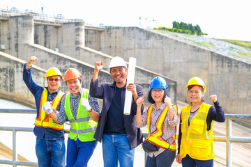 Engineering team Men and woman meeting with Engineers and supervisors are standing reading the blueprints at the construction site.