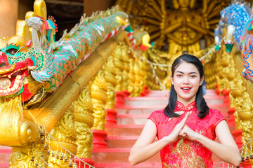 Fototapeta premium Portrait chinese woman red dress traditional cheongsam in chinese temple.