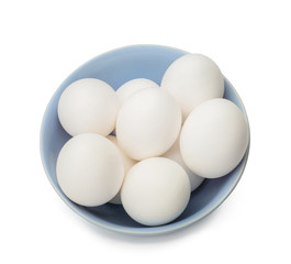 Bowl with raw chicken eggs on white background