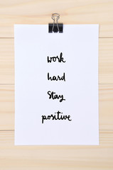 Work hard Stay positive on white paper with wooden background