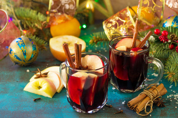 Christmas Mulled Wine or Sangria with Spices. Two glasses of hot mulled wine with Apple and spices on blue slate table.