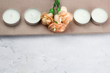 candles and fresh flowers on a napkin on a marble table
