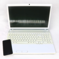 white laptop and smartphone on a light background
