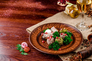 Georgian dish - phali of spinach and meat on a brown plate on a wooden background. close-up