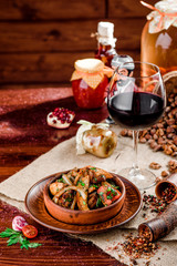 Fried potatoes slices in a brown plate and a glass of red wine on burlap on a dark wooden background. beautiful composition. Georgian cuisine. top view. close-up