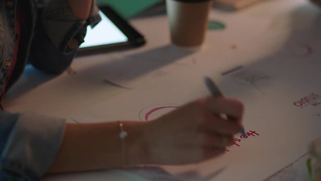 close up hands business people working late marketing team designing company logo brainstorming ideas planning creative project deadline in office at night