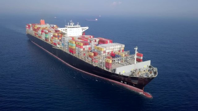 Container ship at sea - Aerial footage of a ULCV (Ultra large container vessel) loaded with various container brands.