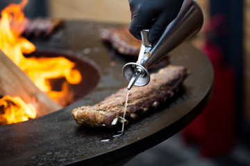 Grilled pork baby ribs with barbecue sauce on the grill. Festival street food