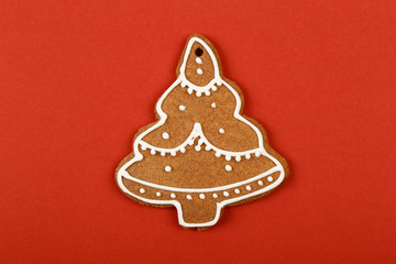 Christmas cookies, gingerbread In the form of a Christmas tree on red background. Christmas background