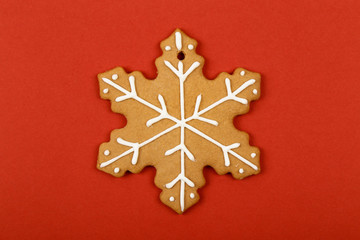 Christmas cookies, gingerbread In the form of a snowflake on red background. Christmas background