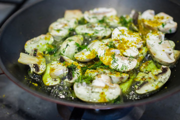 Roasted mushrooms in skillet pan with herbs and greens