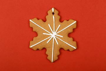 Christmas cookies, gingerbread In the form of a snowflake on red background. Christmas background