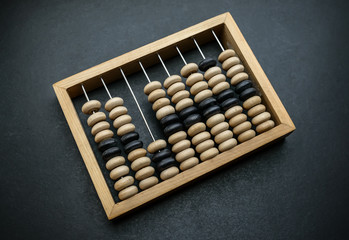 Old wooden abacus on dark background.