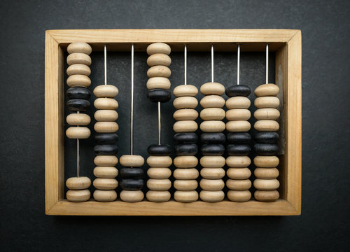 Old wooden abacus on dark background.