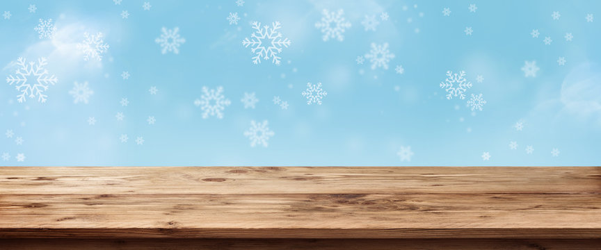 Blue snowflakes background with wooden table