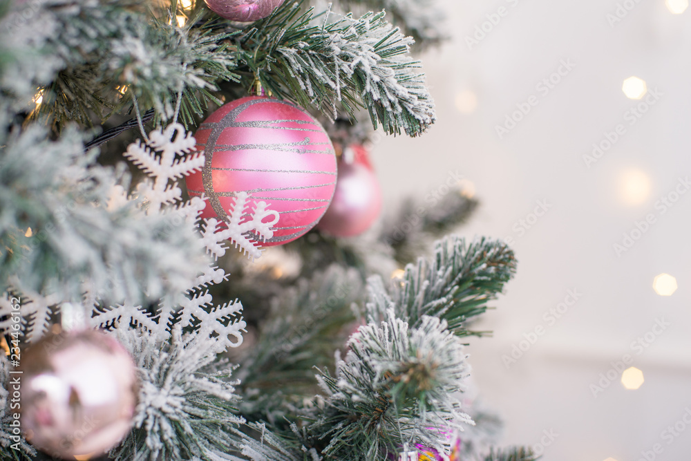 Wall mural decorated in a pink christmas tree on a blurred, sparkling and fabulous background.