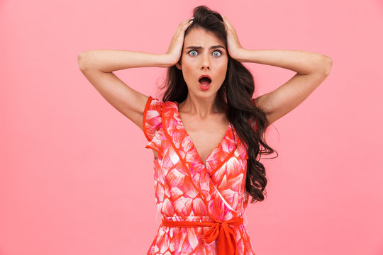 Excited shocked young woman posing isolated over pink background wall.