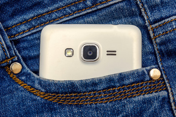 Mobile phone in blue jeans pocket. Close-up