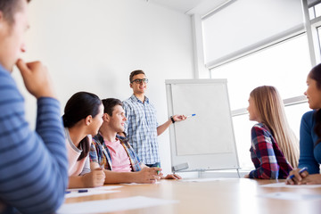 Fototapeta premium education, teamwork and people concept - group of high school students with flip chart